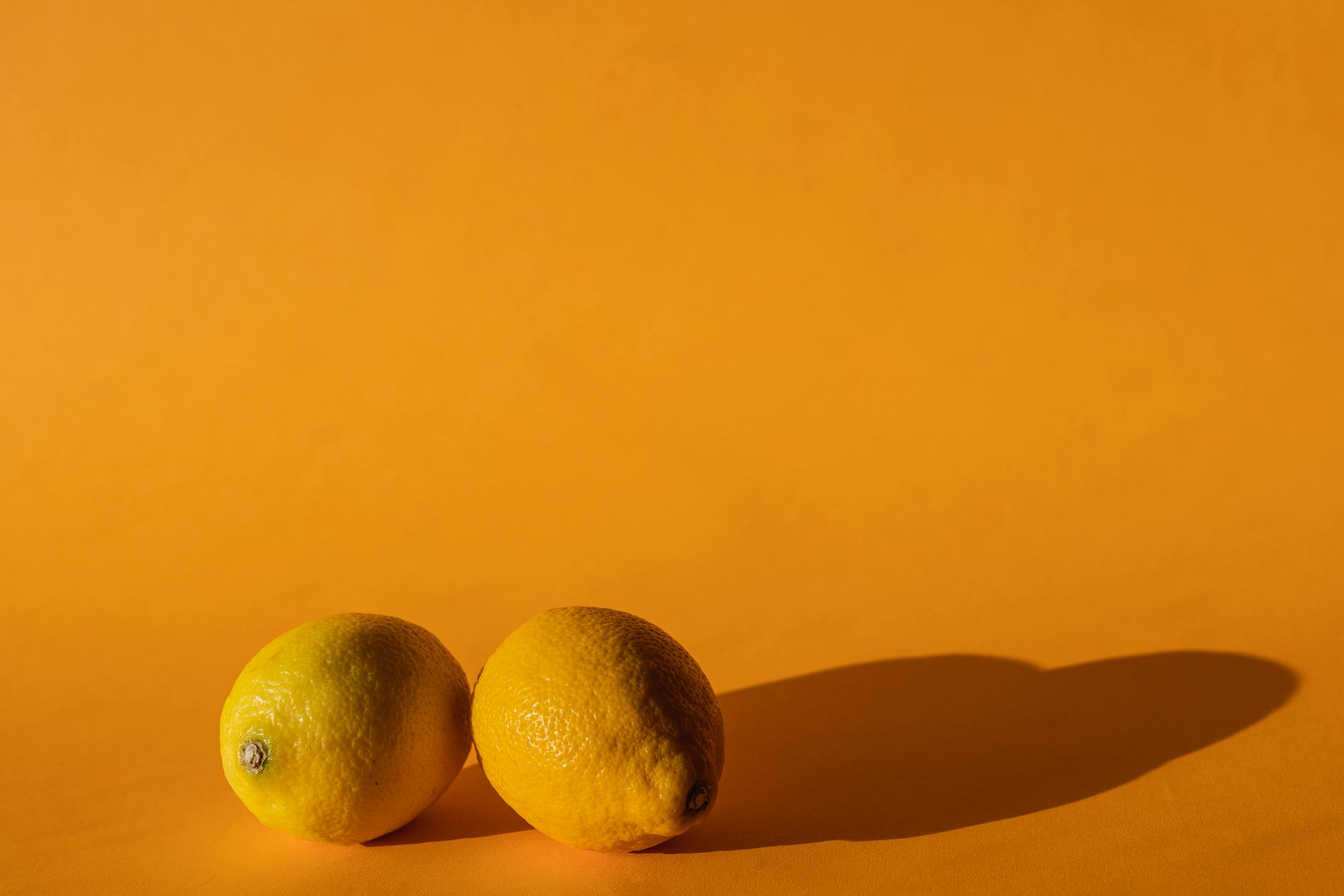 Bright yellow lemons on a yellow background, symbolizing sensation and vitality